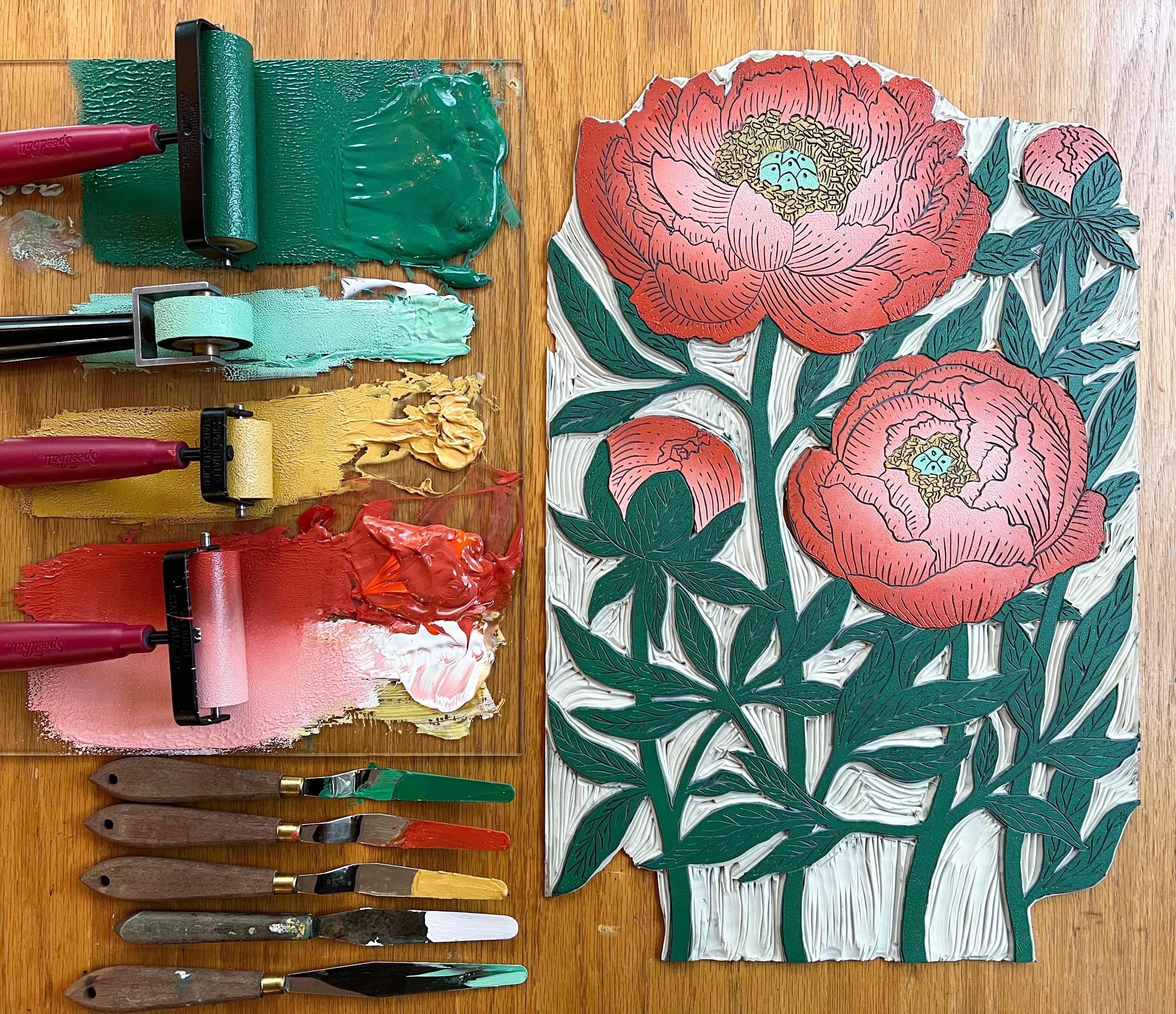 Flatlay of a floral vinyl carving and the paint applied